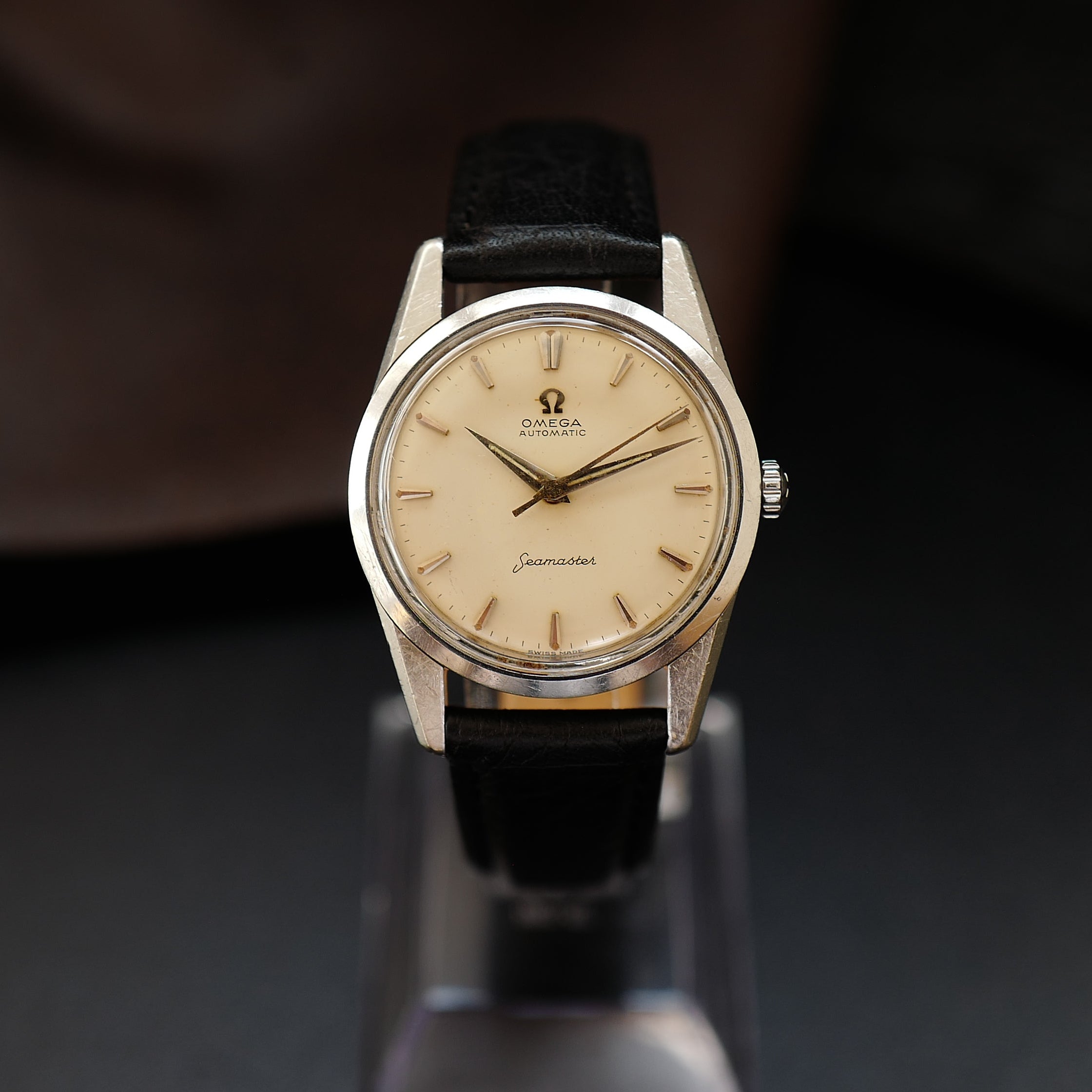 Montre Omega Seamaster avec cadran crème argenté et bracelet en acier inoxydable, affichage analogique élégant.