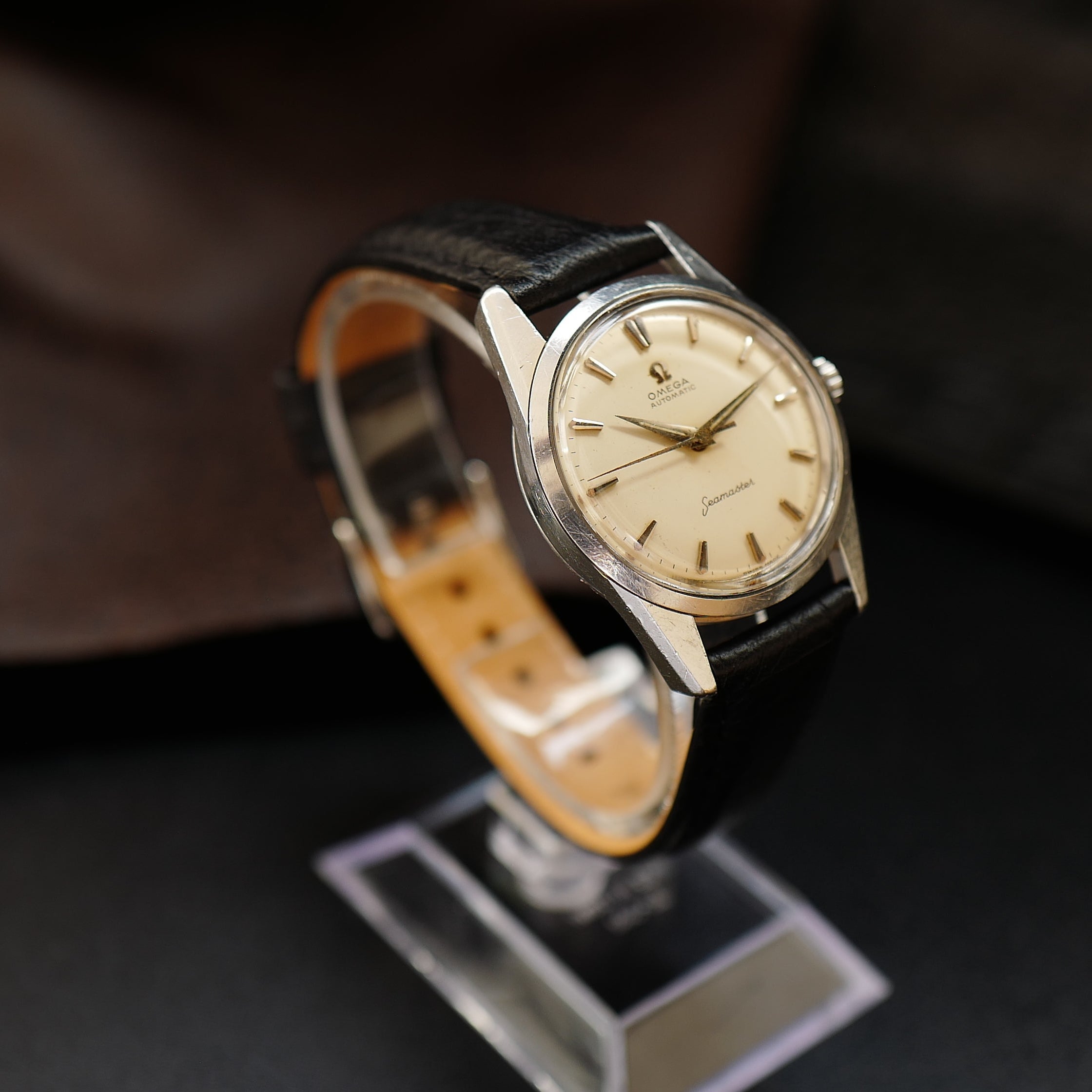 Montre Omega Seamaster avec cadran crème argenté et bracelet en acier inoxydable, élégance et précision horlogère.