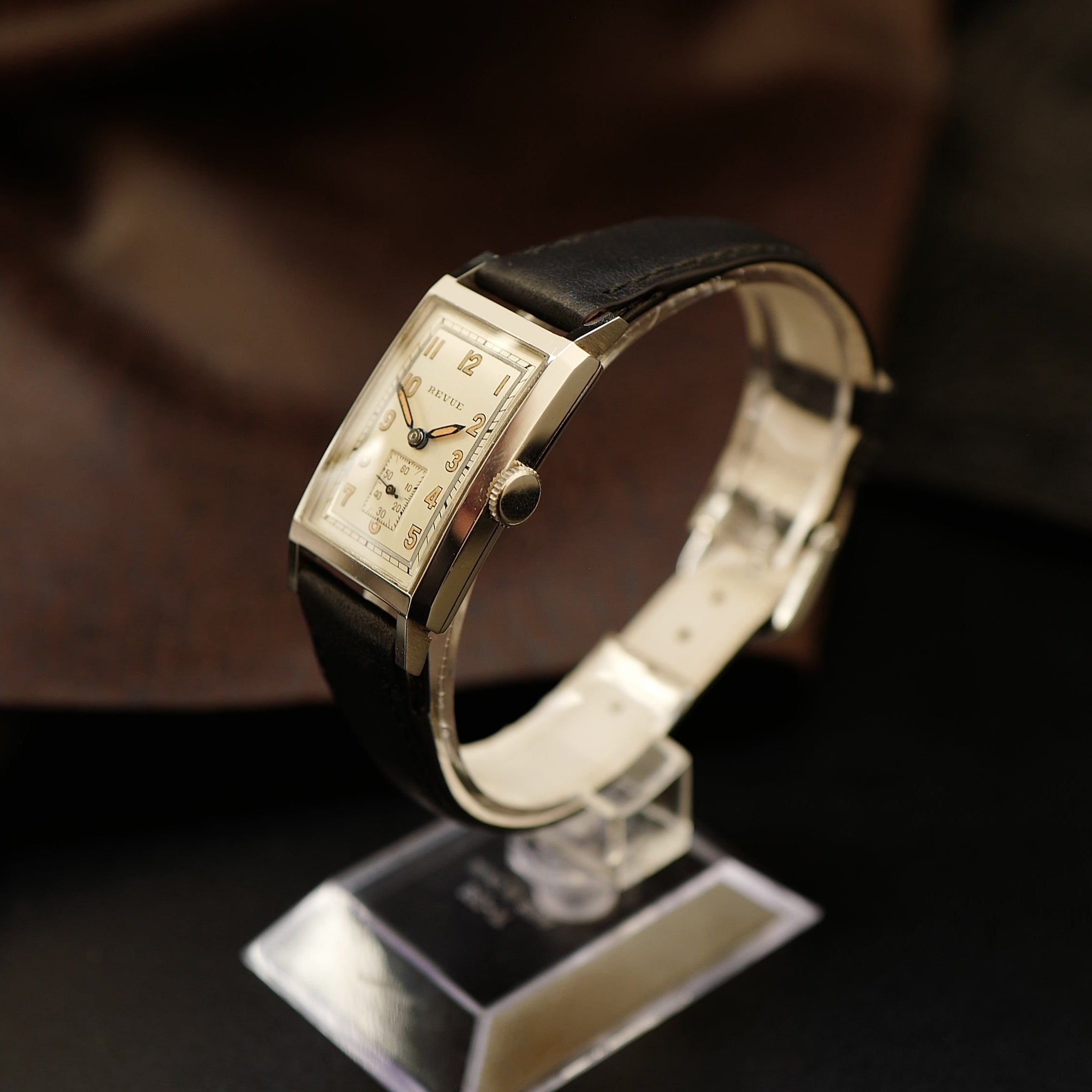 Montre Revue Type Tank Art Deco WWII N.O.S avec cadran noir, boîtier en acier et bracelet en cuir, style vintage militaire.