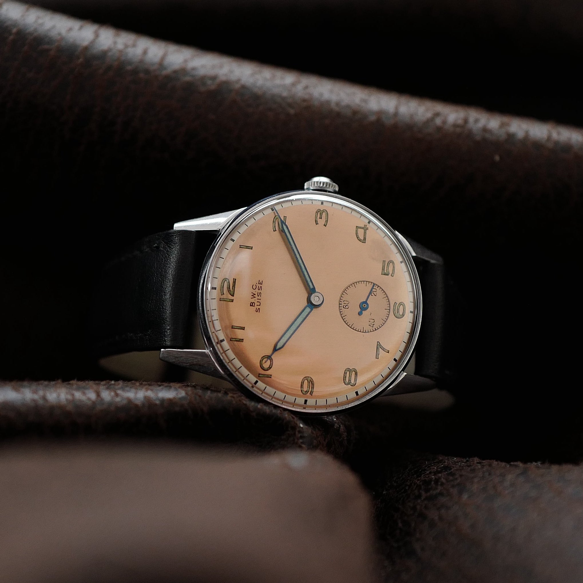 Montre BWC des années 1950 avec cadran saumon à deux tons, style vintage élégant, boîtier en acier inoxydable.
