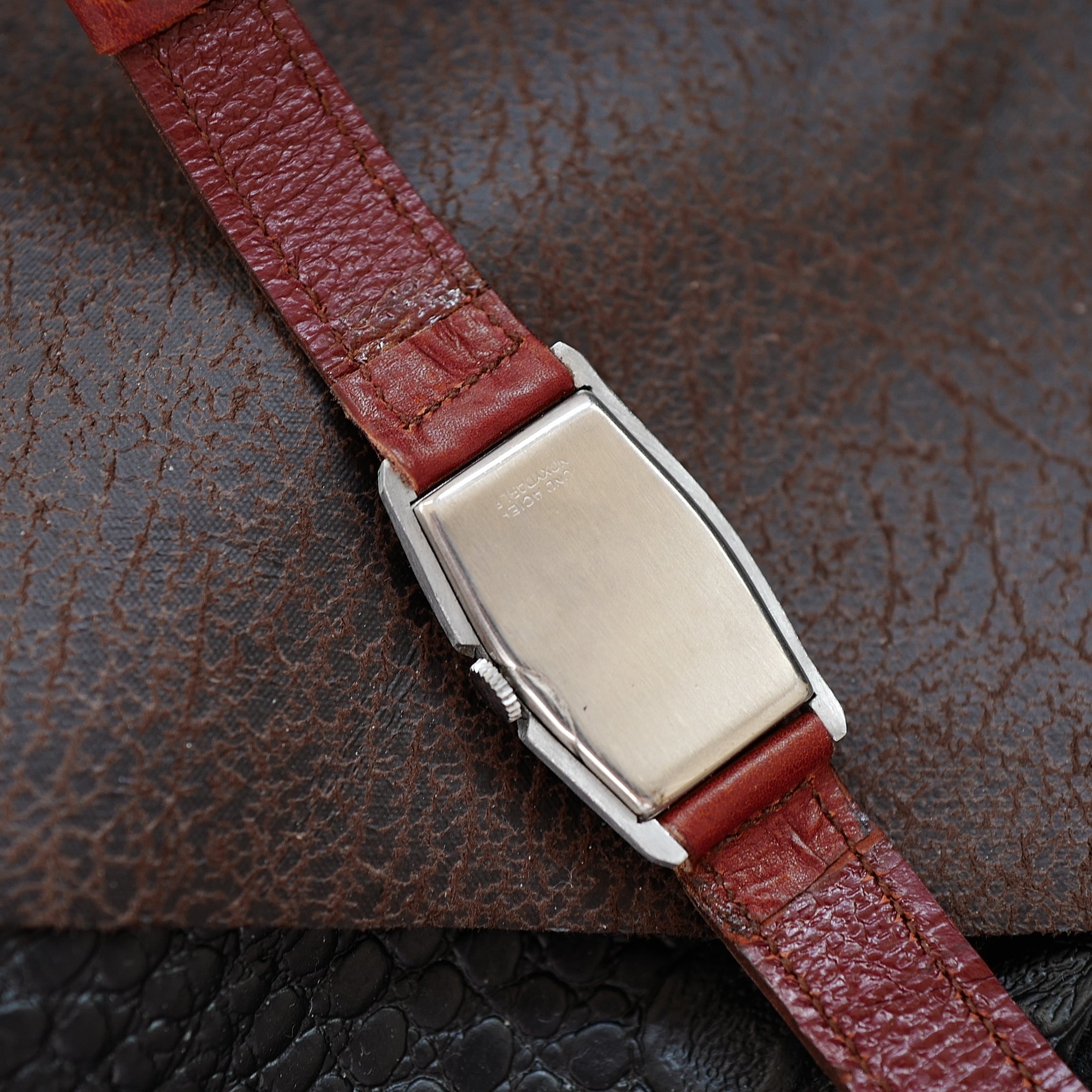 Montre tonneau Art Déco Huma deux tons des années 1940, boîtier en métal avec cadran élégant et détails vintage.