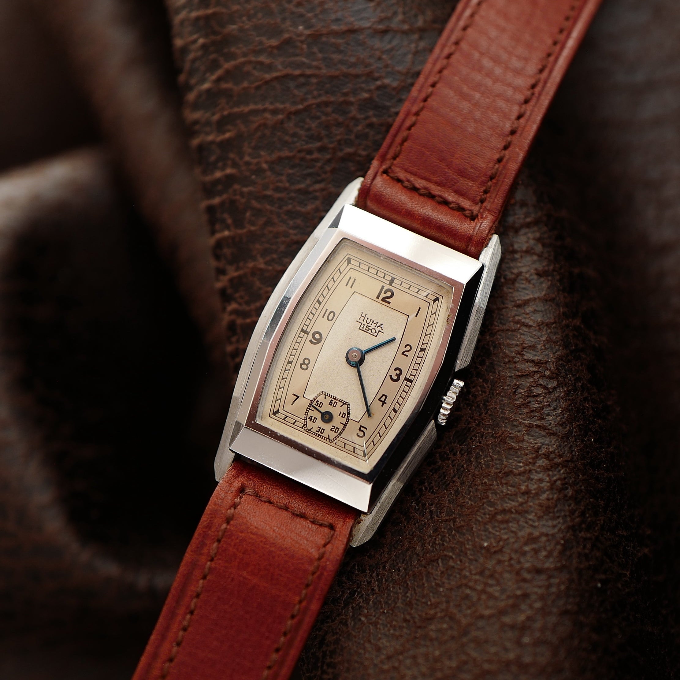 Montre tonneau Art Déco deux tons Huma des années 1940, boîtier en acier avec détails dorés, cadran élégant et vintage.