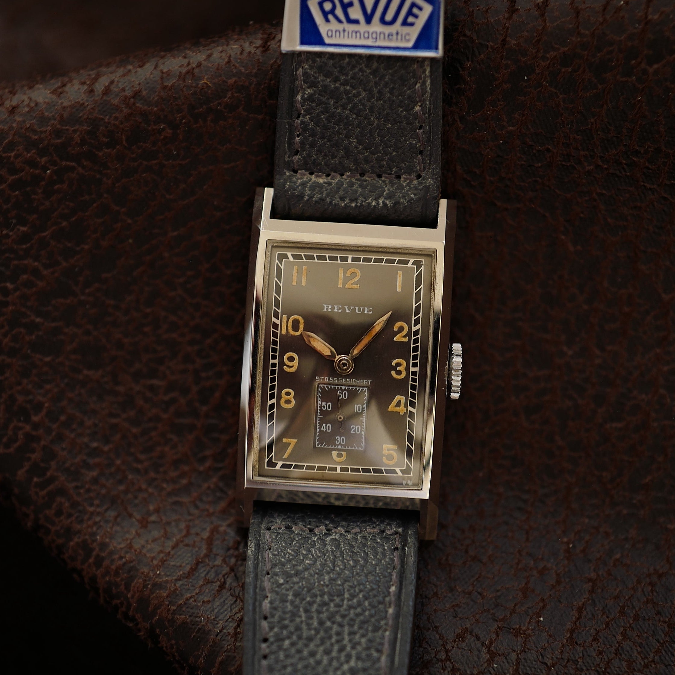 Montre Revue Type Tank grise avec cadran art déco, vintage WWII N.O.S, boîtier en acier, style militaire élégant.