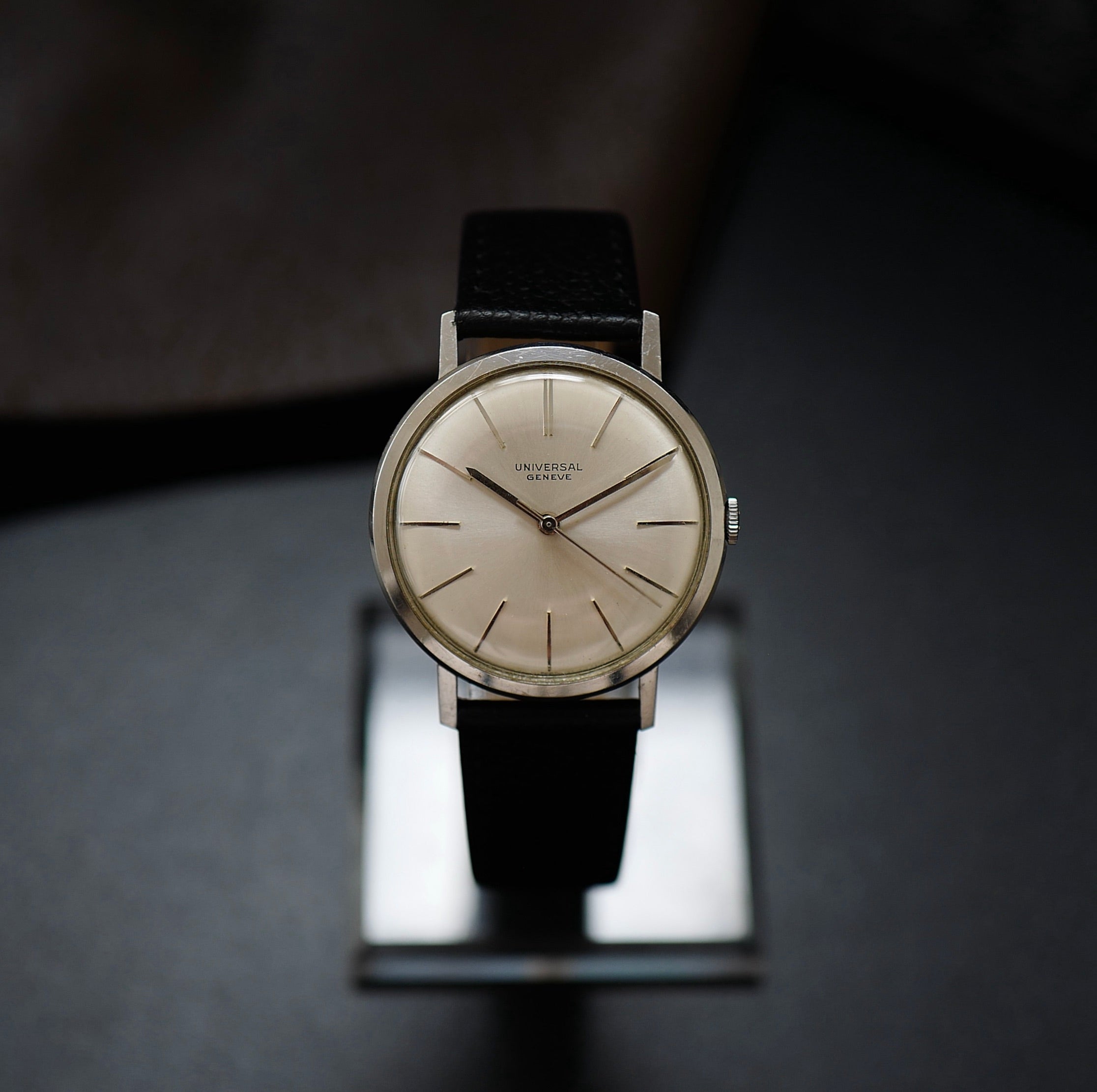 Montre Universal Genève à boîtier fin en argent et cadran des années 1960, vue de face, détails élégants et style vintage.