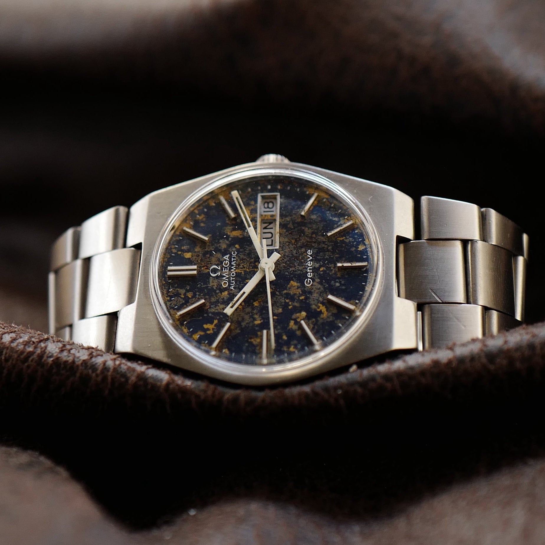 Montre Omega Genève Day Date bleu météorite des années 1970, modèle 166.0125, affichage jour et date, cadran élégant.