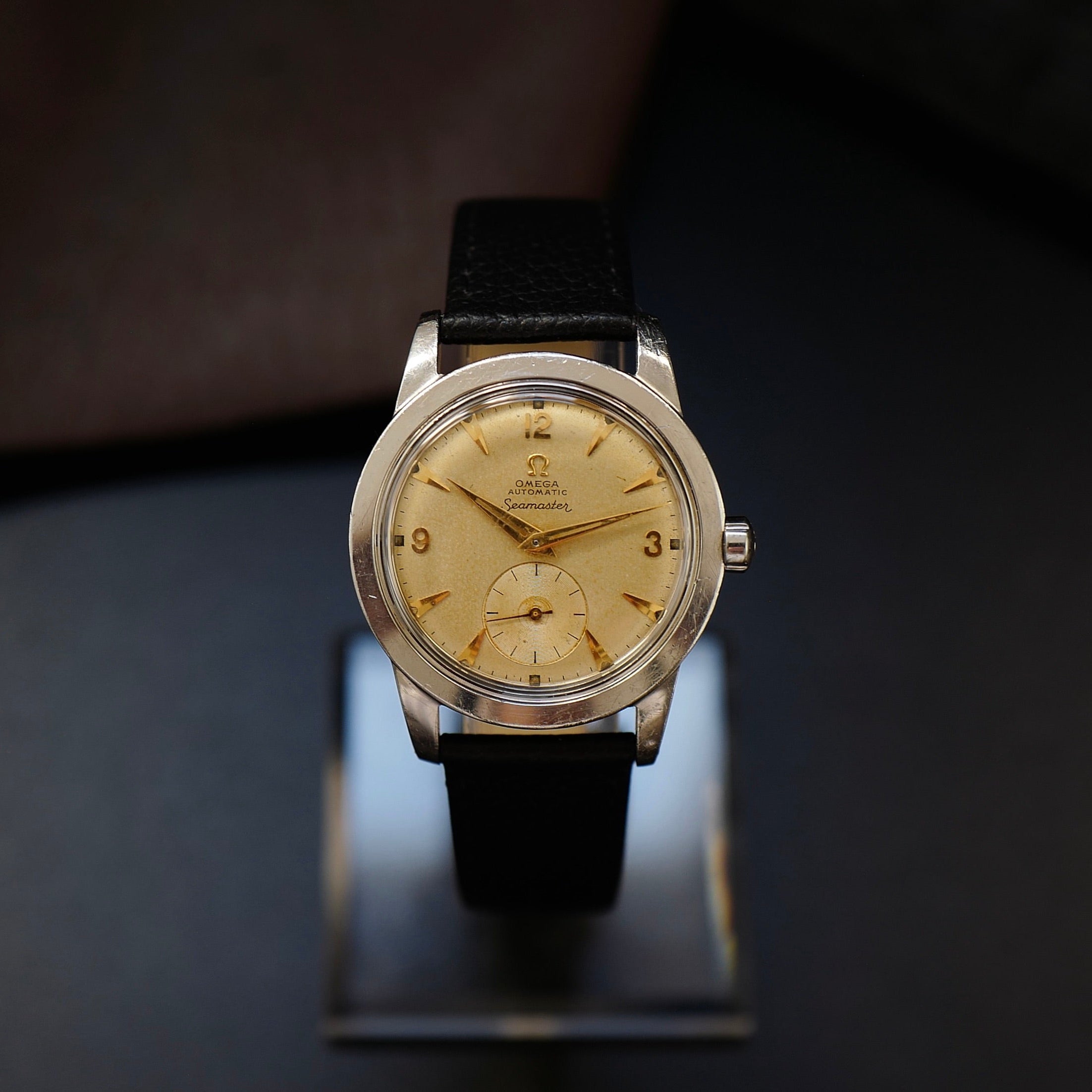 Montre Omega Seamaster Sand Dial avec petite seconde, style années 1950, boîtier en acier, cadran beige clair.