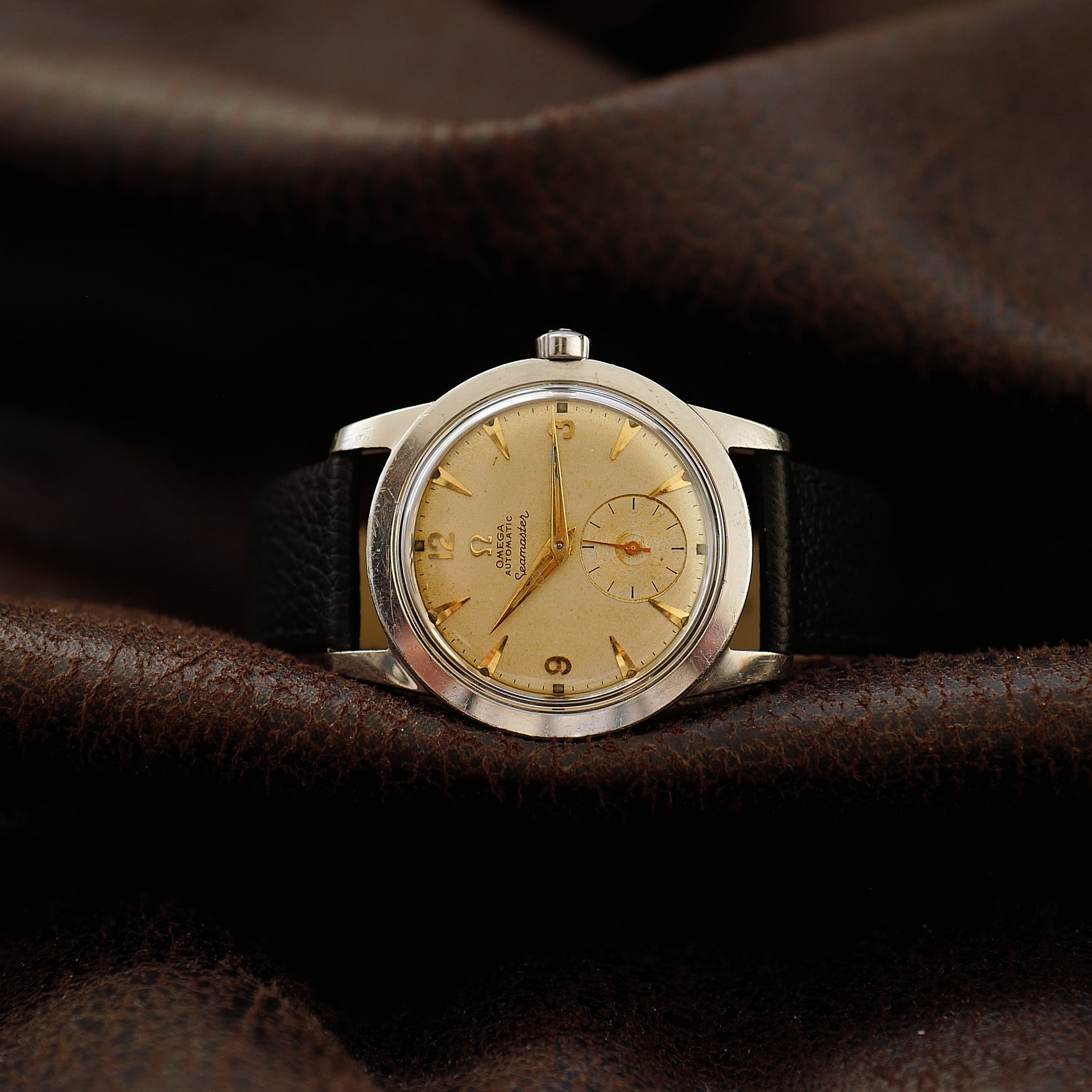 Montre Omega Seamaster avec cadran sable et petite seconde des années 1950, style vintage et design élégant.