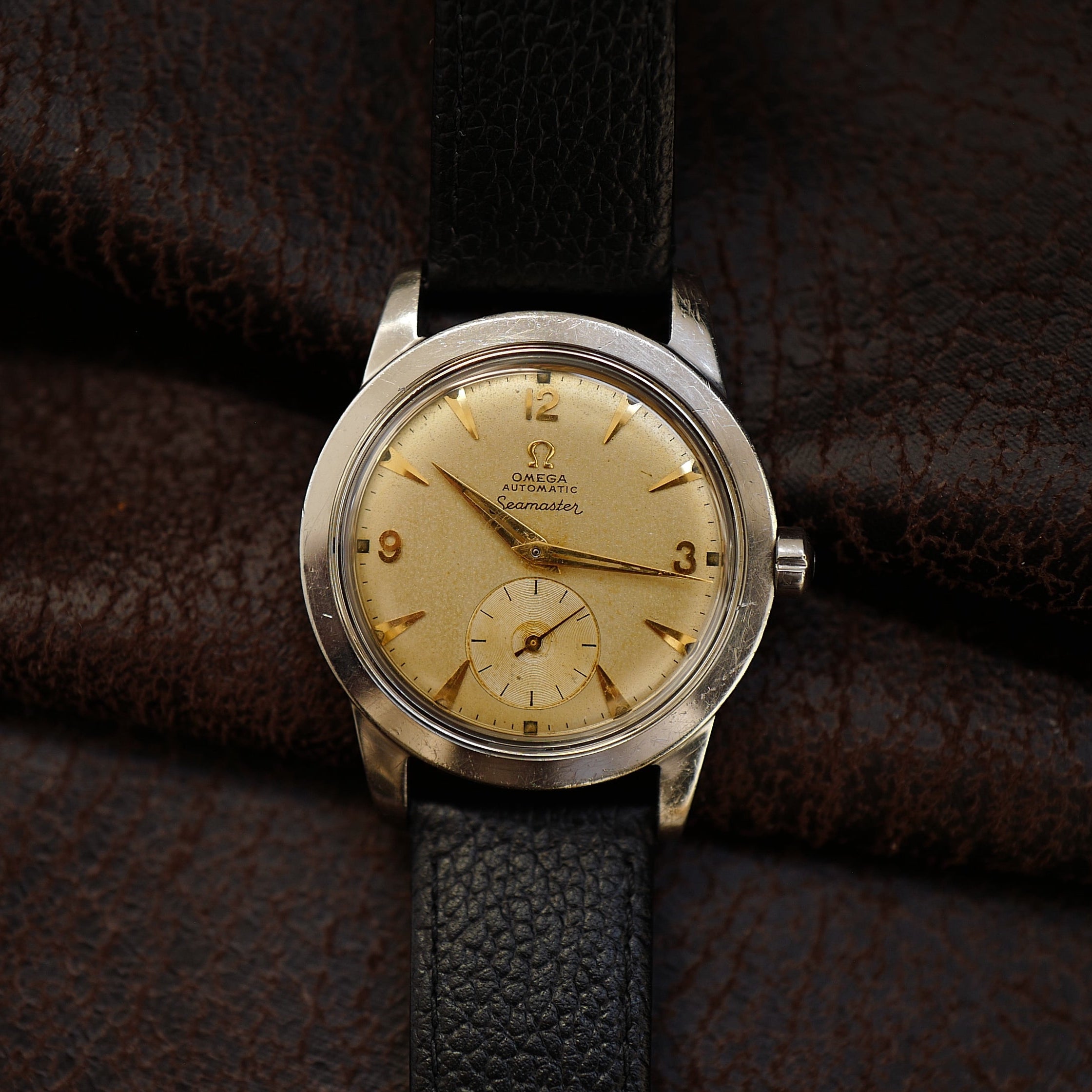Montre Omega Seamaster Sand Dial avec petite seconde, style années 1950, cadran beige et boîtier en acier.