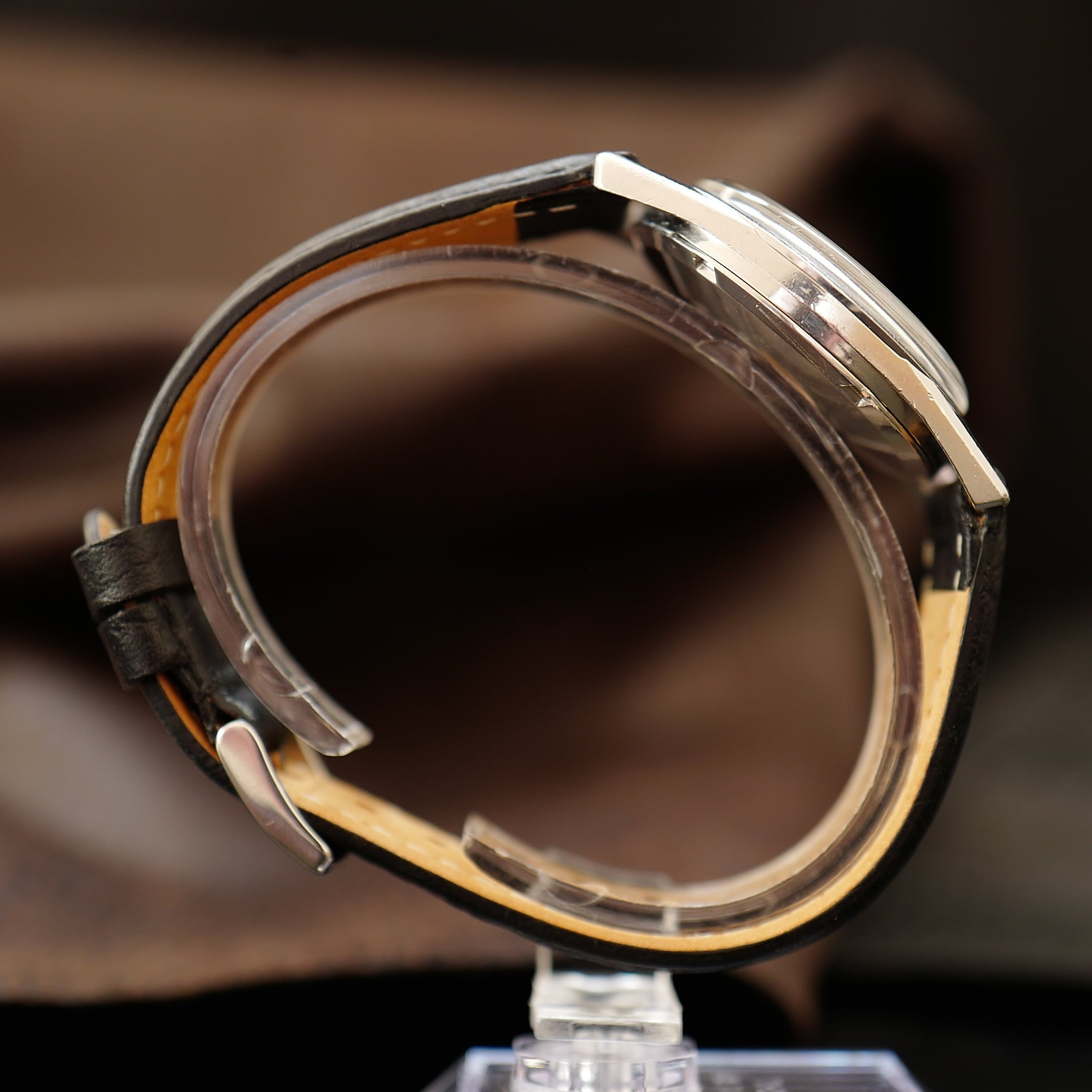 Montre Omega Seamaster avec cadran crème argenté et boîtier en acier inoxydable visible sur fond blanc.