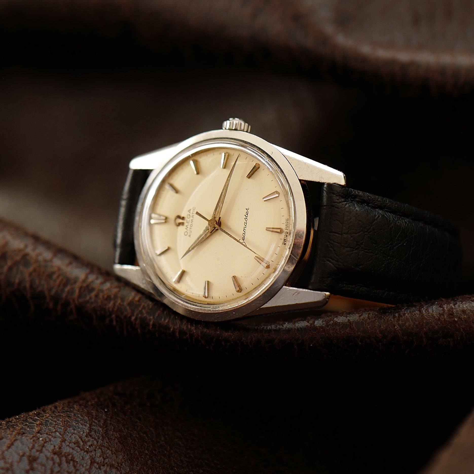 Montre Omega Seamaster avec cadran crème argenté et bracelet en acier inoxydable, vue rapprochée du visage de la montre.