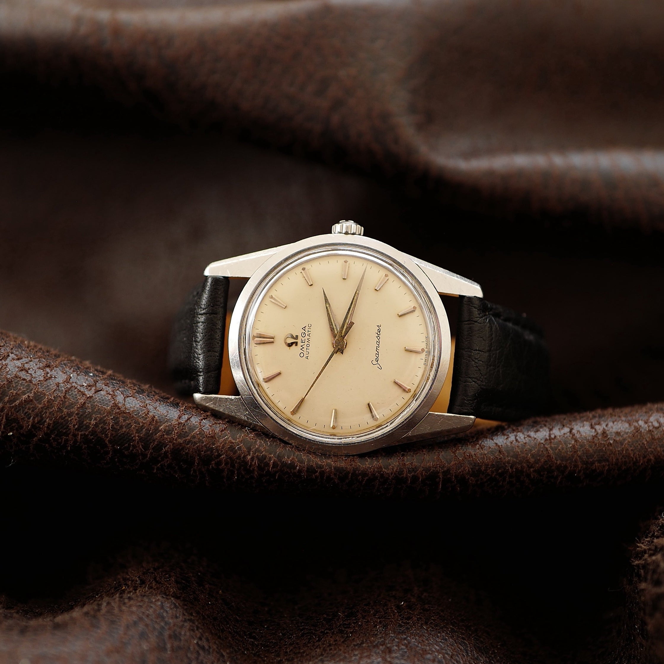 Montre Omega Seamaster avec cadran crème argenté et bracelet en acier inoxydable, vue rapprochée.