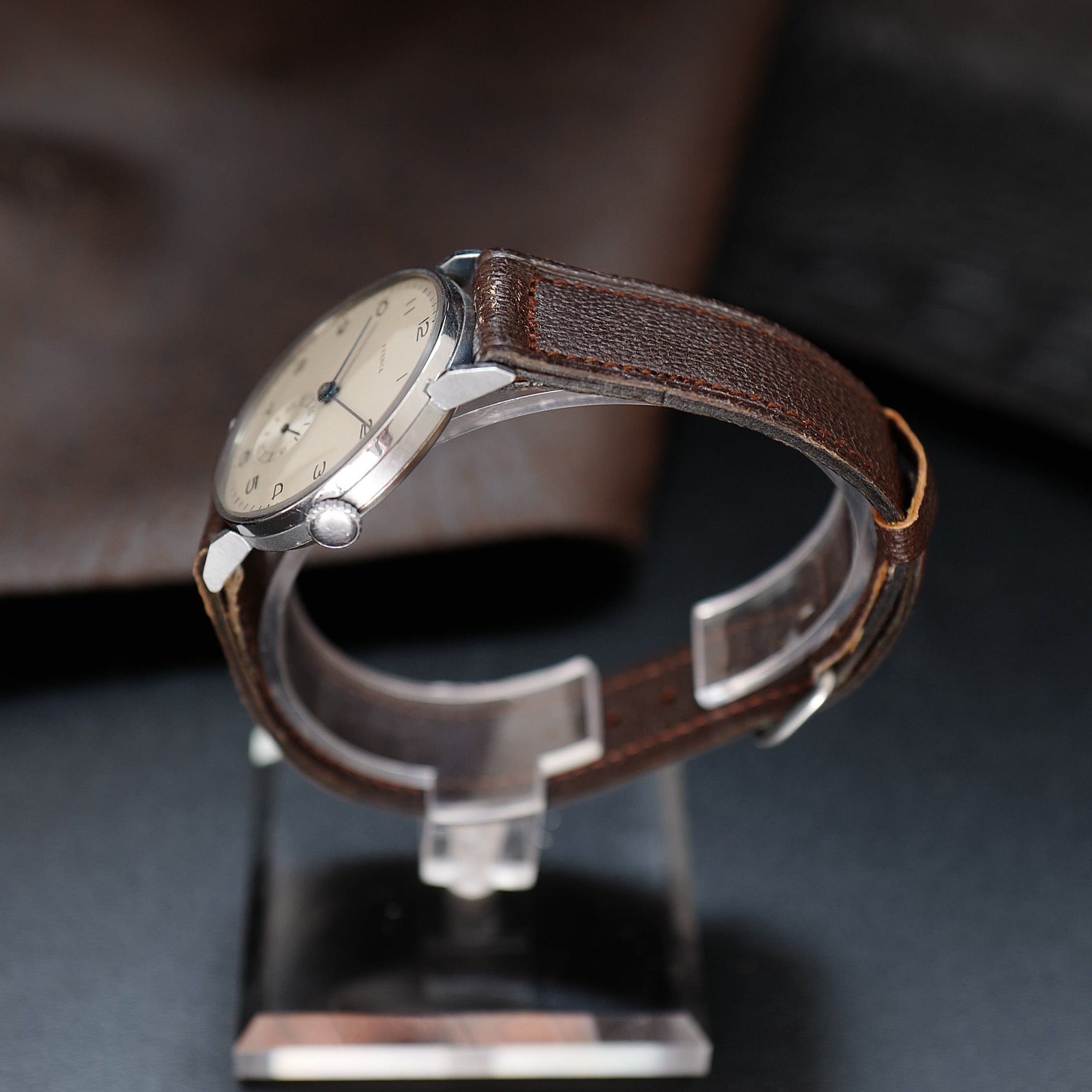 Montre Frenca Type Calatrava WWII Buser Frères N.O.S avec cadran blanc et bracelet en cuir noir.