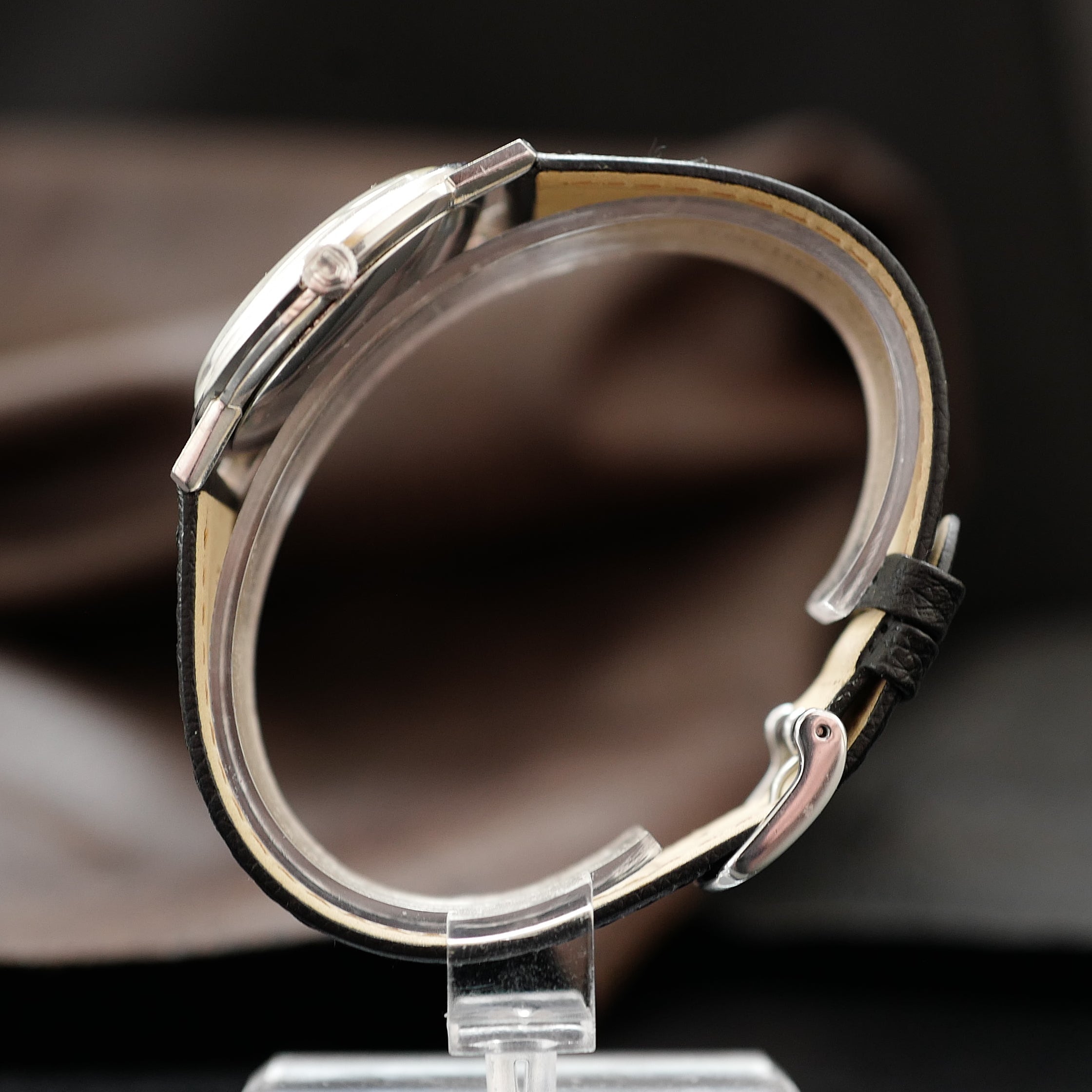 Montre Universal Genève à boîtier fin, cadran argenté, style années 1960, montre-bracelet élégante et classique.