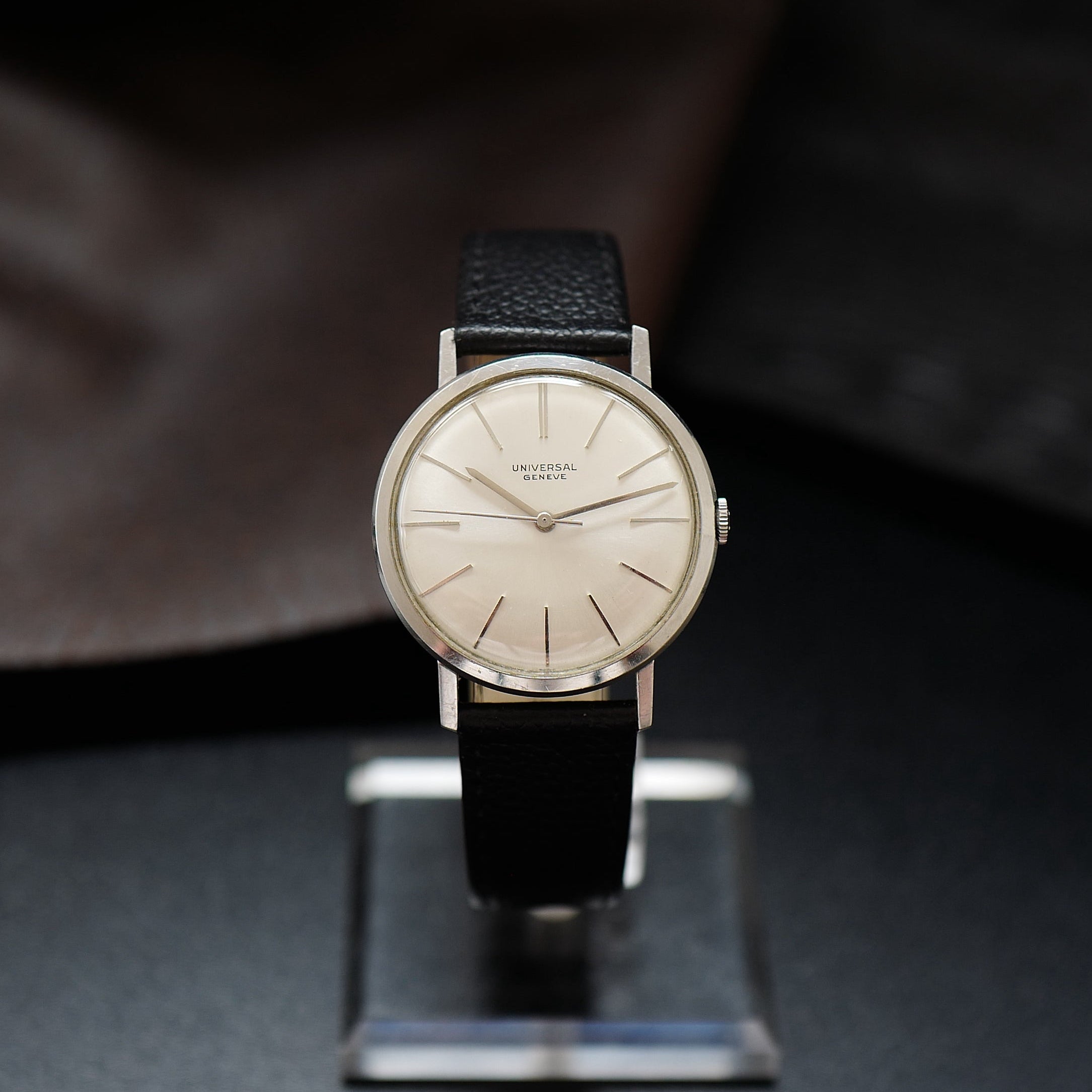 Montre Universal Genève à boîtier fin en argent avec cadran vintage des années 1960, affichage analogique élégant.