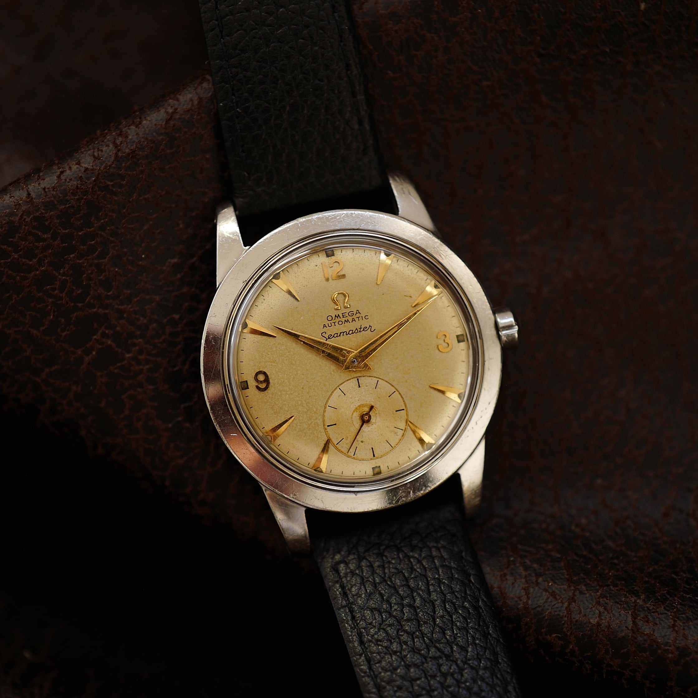Montre Omega Seamaster Sand Dial avec petite seconde, style années 1950, boîtier en acier et cadran beige.