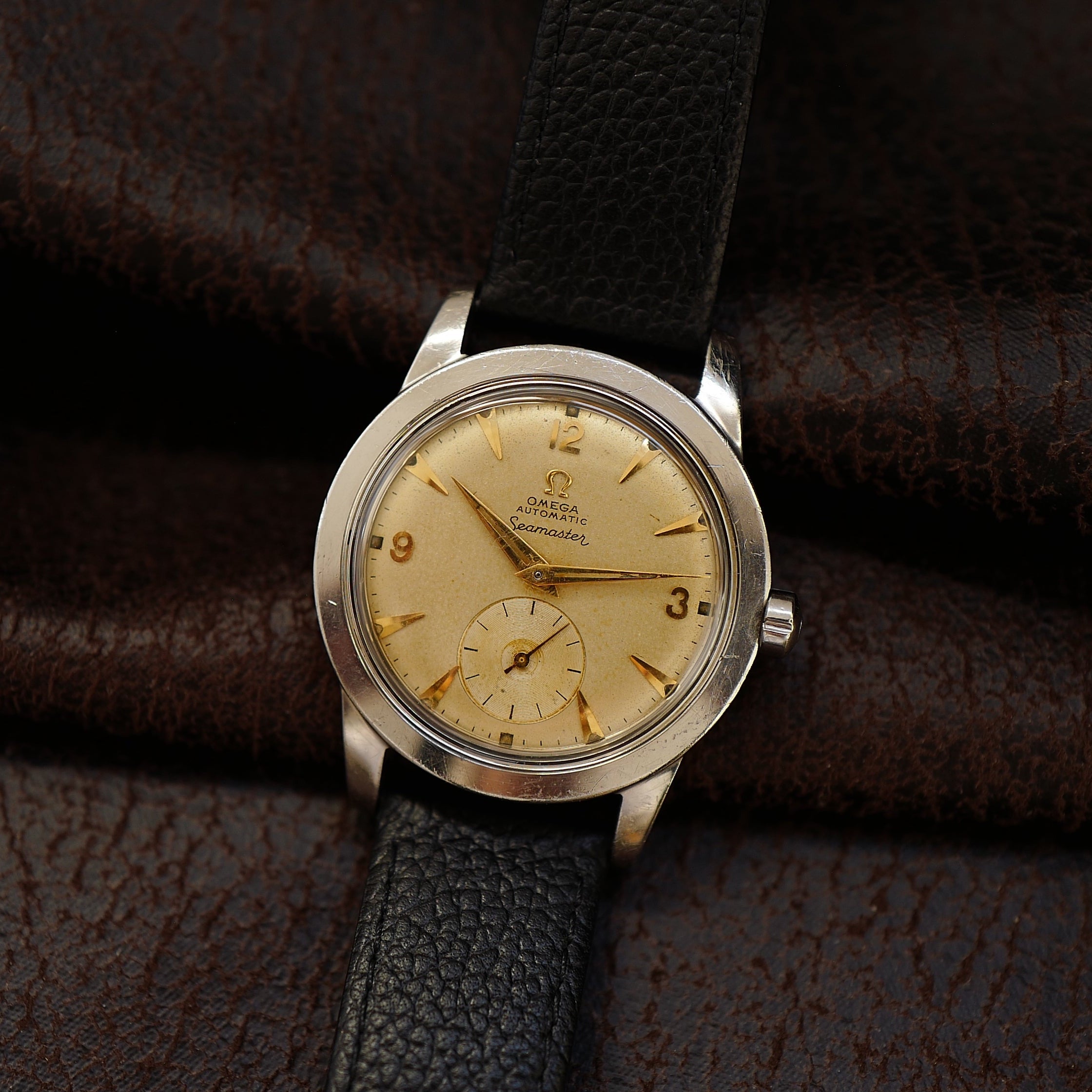 Montre Omega Seamaster avec cadran sable et petite seconde, style années 1950, montre-bracelet vintage élégante.